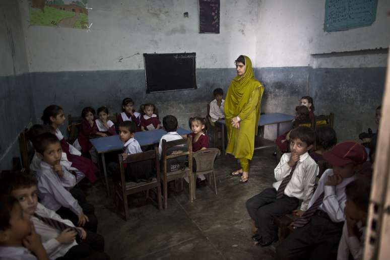 <p>Professora e alunos de uma escola de Rawalpindi reunidos durante uma celebração pela lembranda de um ano do atentado contra Malala; em Mingora não houve comemoração</p>