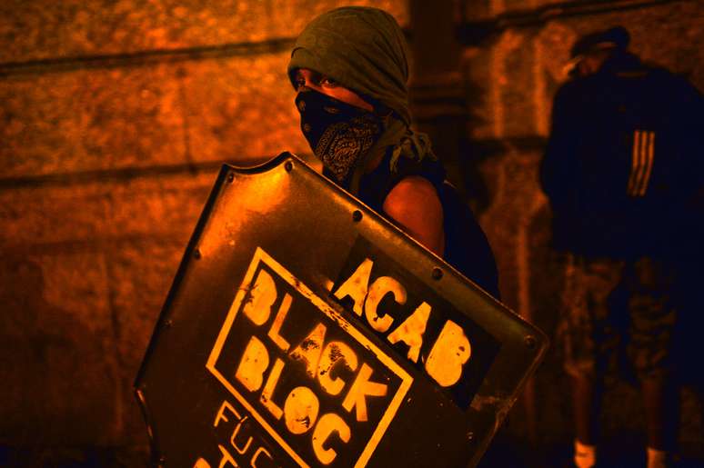 <p>Jovem mascarado exibe a marca do Black Bloc durante protesto no Rio de Janeiro</p>