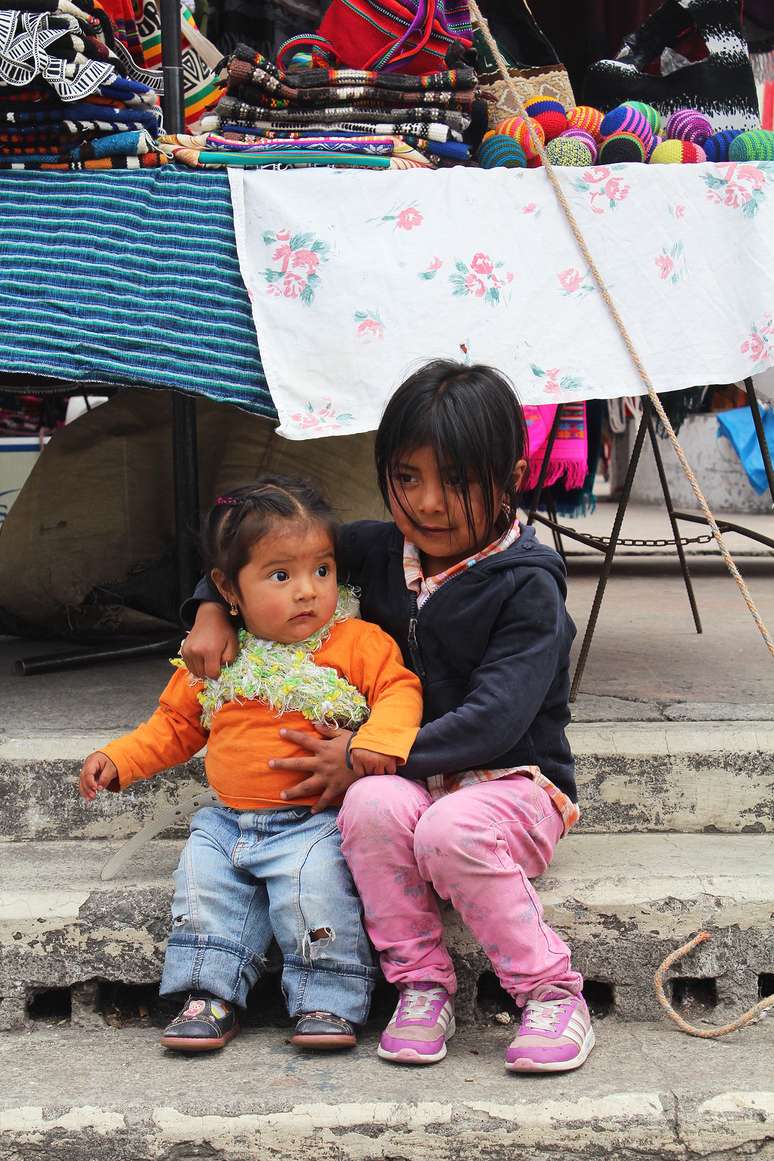 <p>Crianças acompanham os pais que trabalham no mercado aberto de Otavalo</p>