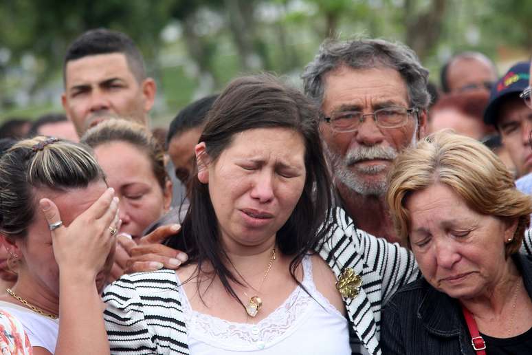 Viúva de PM morto em tiroteio chora durante sepultamento no Rio