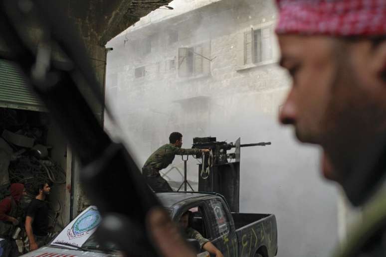 Membros do Ex&eacute;rcito LIvre da S&igrave;ria lutam contra soldados do regime em Askar, nos sub&uacute;rbios de Aleppo, em foto de outubro de 2012