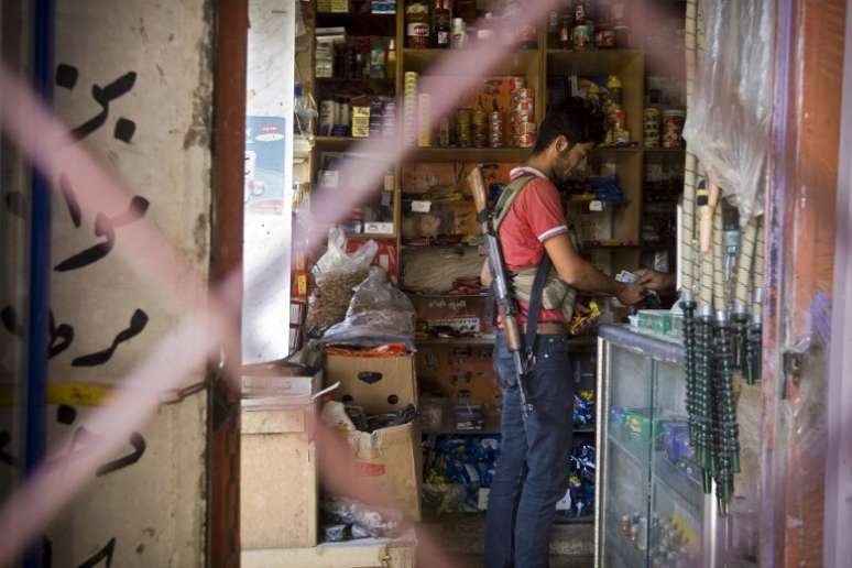 Soldado rebelde compra barra de chocolate em um mercado nos sub&uacute;rbios de Aleppo, em foto de setembro de 2013