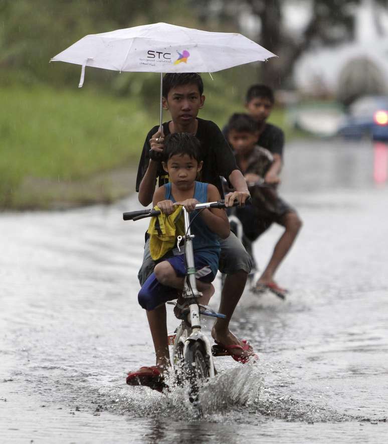 Crianças circulam pelas ruas inundadas de Taguig 