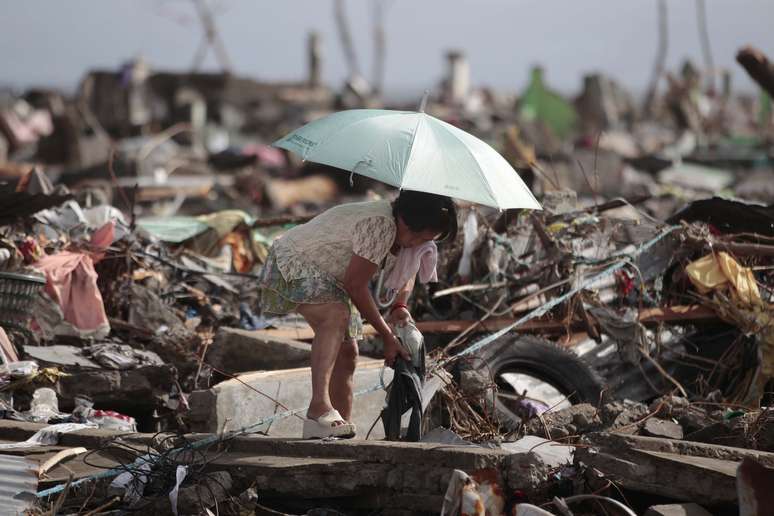 Em meio aos destroos, sobrevivente tenta resgatar pertences em Tacloban