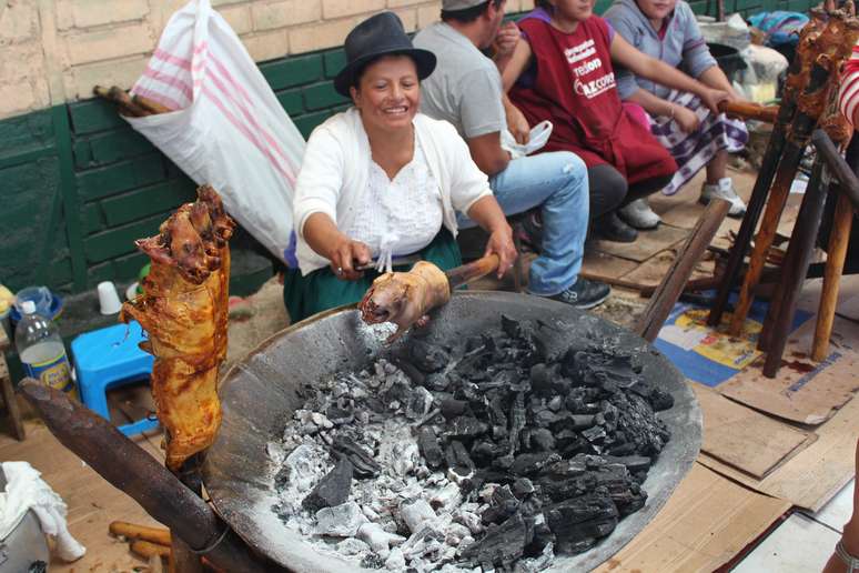 <p>Mercado de Gualaceo é movimentado aos domingos; comerciante prepara cuye no carvão</p>