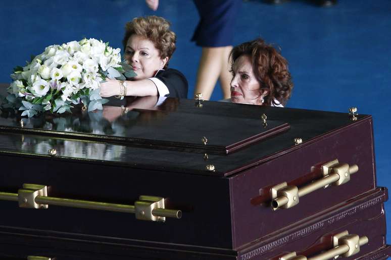 <p>Ao lado da viúva de Jango, Maria Teresa Goulart (dir.), Dilma deposita flores sobre o caixão do ex-presidente</p>