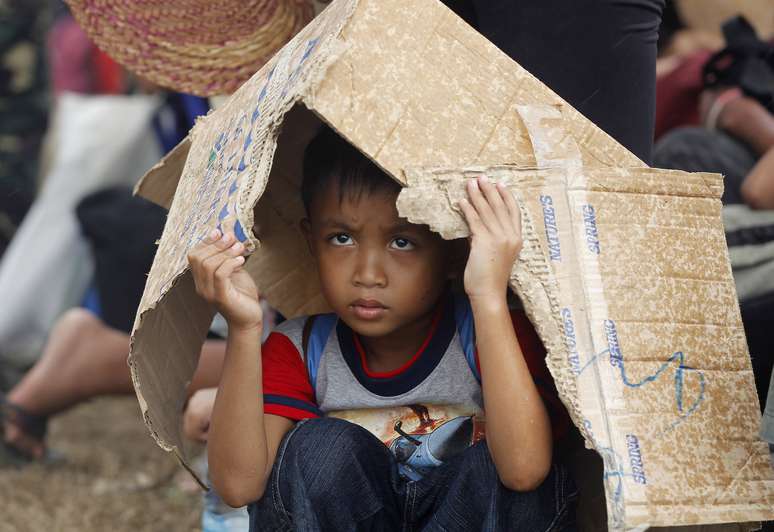 Criança aguarda um voo de evacuação no aeroporto de Tacloban
