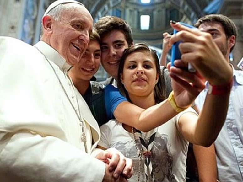 <p>Jovens tiram selfie com Papa Francisco; para especialista, piolhos podem ser transmitidos quando os jovens tiram fotos juntos</p>