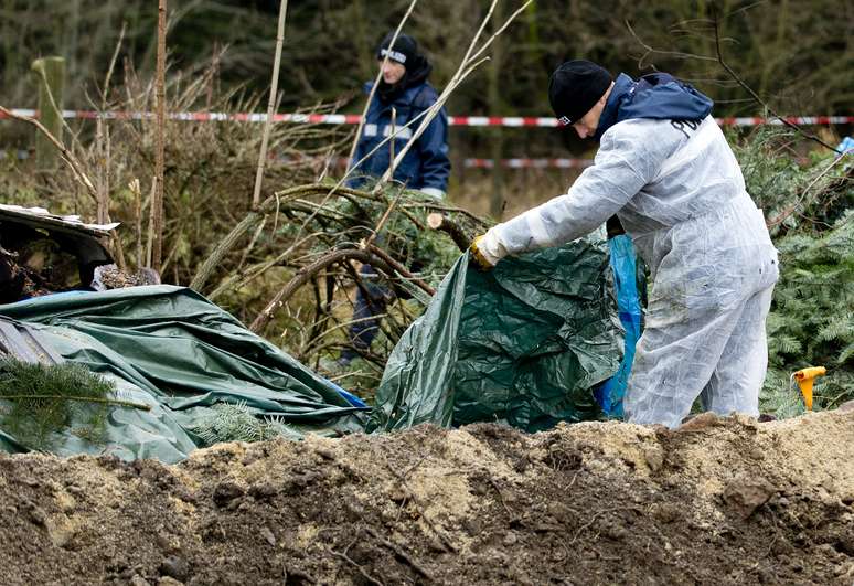 Policias buscam evidências no local onde os restos mortais da vítima foram encontrados