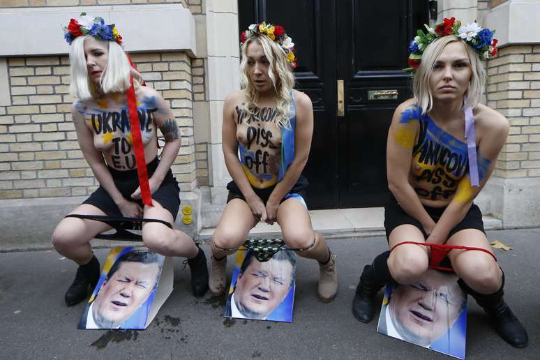 <p>Ativistas do Femen urinam sobre fotos do presidente ucraniano em Paris, durante ato em apoio aos protestos pró-União Europeia na Ucrânia</p>