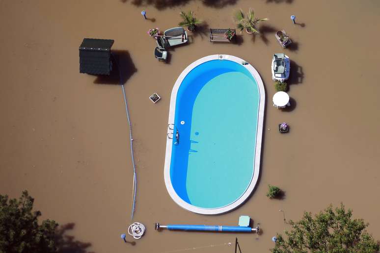 <p>Jardim com piscina é alagado pelas cheias do Rio Elba em Magdeburg, Alemanha, em 10 de junho. Dezenas de milhares de pessoas foram afetadas na Europa pelas piores enchentes da década</p>