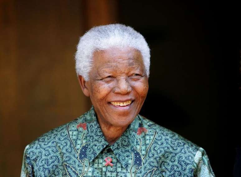 <p>Nelson Mandela sorri para fotógrafos em sua casa em Johanesburgo, na África do Sul, em setembro de 2005</p>