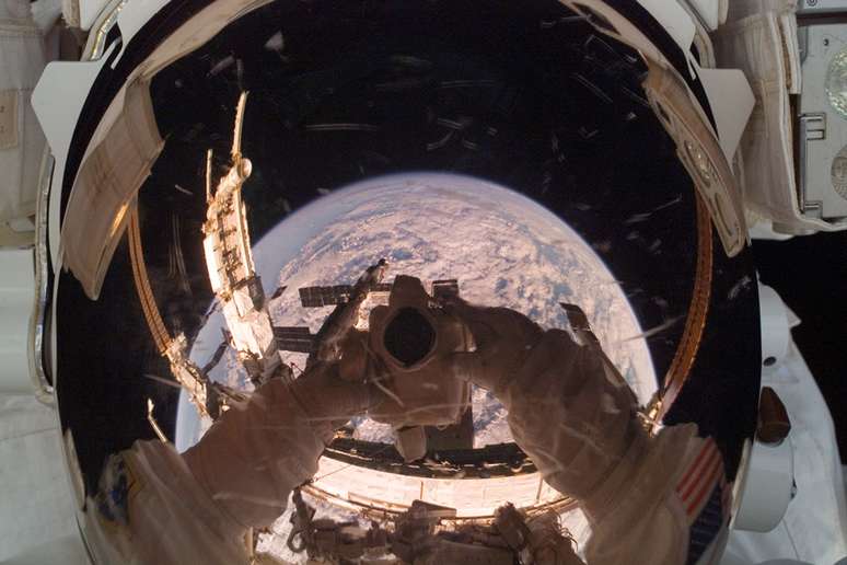 <p>A Estação Espacial Internacional (ISS, na sigla em inglês) é refletida no capacete de astronauta</p>