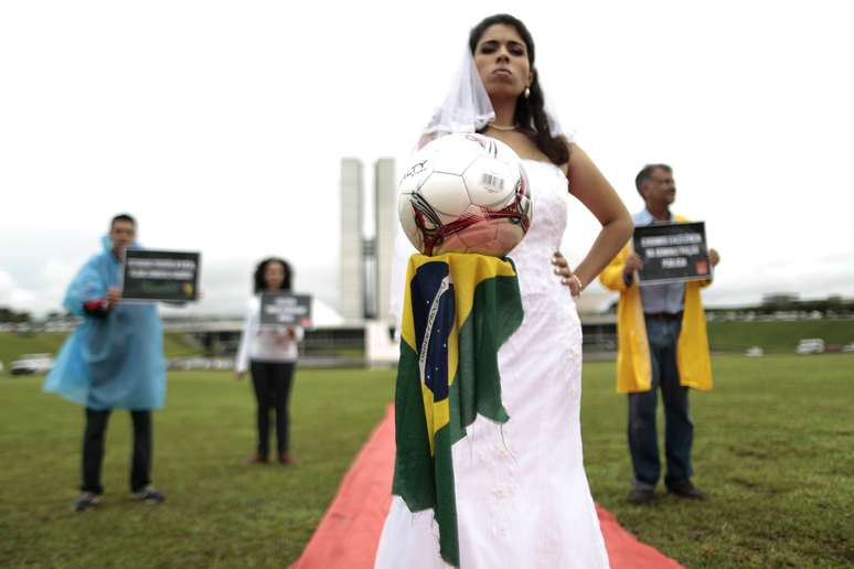 <p>Manifestantes ironizaram declaração do ministro Aldo Rebelo, que comparou estádios a noivas atrasadas</p>