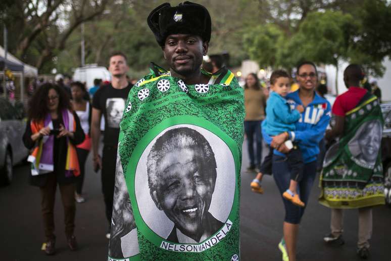 <p>Homem cobre-se com uma bandeira com o rosto de Nelson Mandela</p>