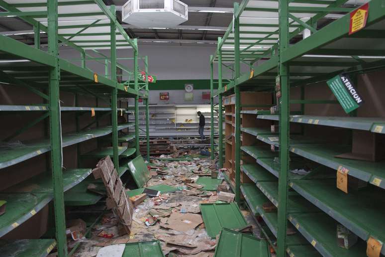 Comerciante inspeciona na terça-feira loja atacada em San Miguel de Tucumán 