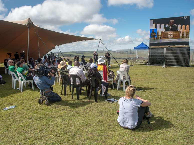 Poucas pessoas apareceram no local montado pelo governo, em Qunu, para os moradores acompanharem o enterro por um telão. Nenhuma das pessoas presentes era moradora do vilarejo