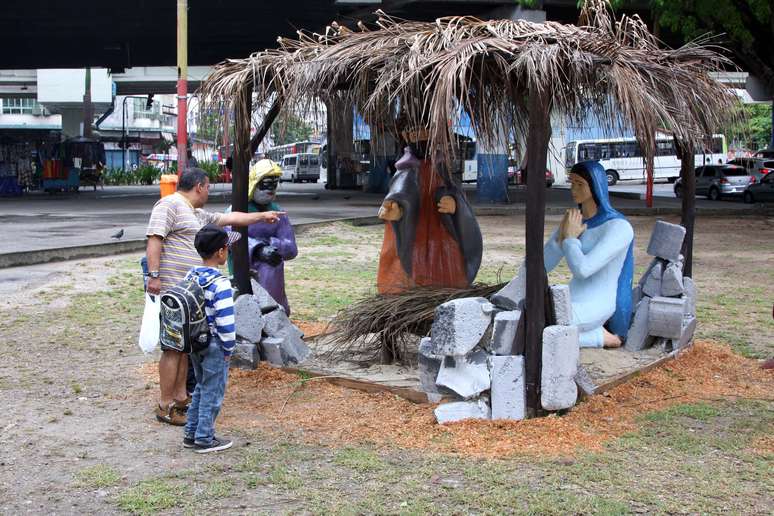 Homem observa o presépio sem a imagem do menino Jesus, em Madureira, zona norte do Rio de Janeiro