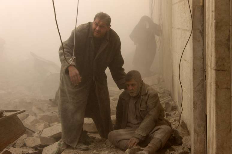 Homem tenta ajudar sírio ferido durante o ataque a Aleppo