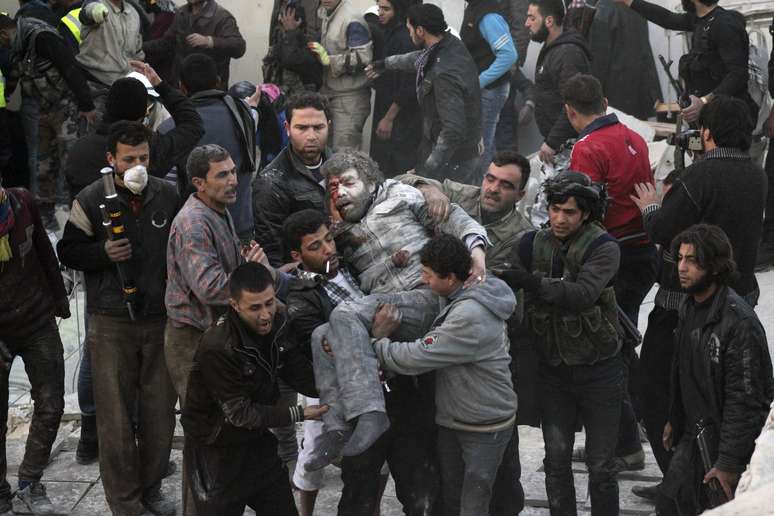 Moradores carregam homem ferido que sobreviveu a bombardeio em Aleppo