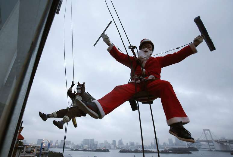 <p><strong>19 de dezembro - </strong>Limpadores de janela trabalham vestidos de Papai Noel em shopping center de Tóquio</p>