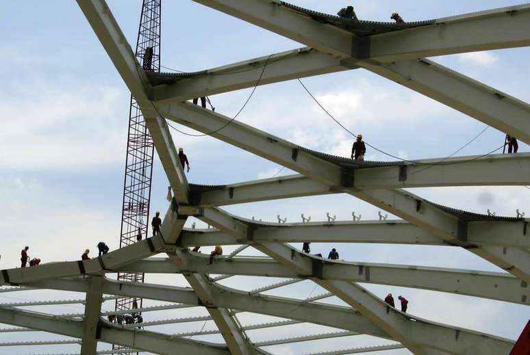 Operários trabalham na estrutura da cobertura da Arena da Amazônia, em Manaus. O Brasil demorou em iniciar as obras para a Copa do Mundo e, a pouco menos de seis meses do torneio, seis estádios correm para finalizar suas construções, o que gera mais riscos de acidentes, segundo o presidente do Sindicato da Arquitetura e da Engenharia. 10/12/2013.