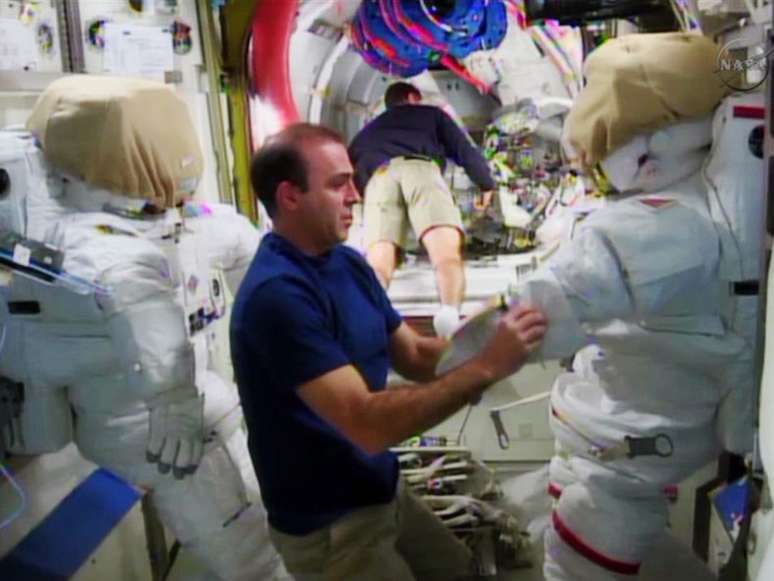 Rick Mastracchio e Mike Hopkins preparam trajes espaciais para a caminhada fora da ISS