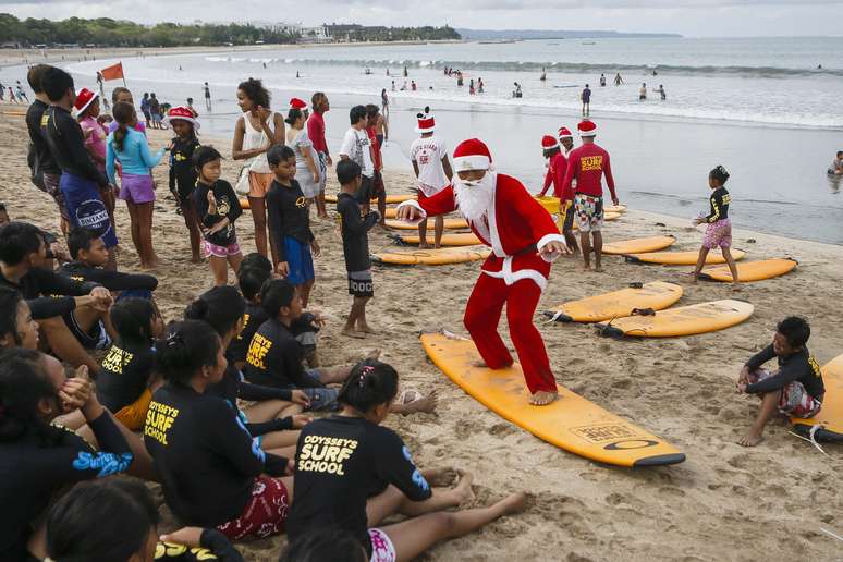 Homem vestido de Papai-Noel ensina crianças a surfar na praia de Kuta, na ilha de Bali, um dos principais destinos turísticos da Indonésia. Mais populoso país de maioria muçulmana do mundo, a Indonésia vê com preocupação a chegada do Natal: o presidente Susilo Bambang Yudhoyono alertou a população para que fique em alerta para a possibilidade de ataques terroristas durante o feriado cristão