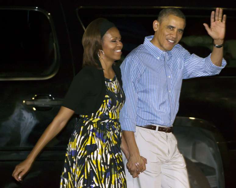 <p>Barack Obama acena ao desembarcar de mãos dadas com Michelle em Honolulu, no Havaí</p>