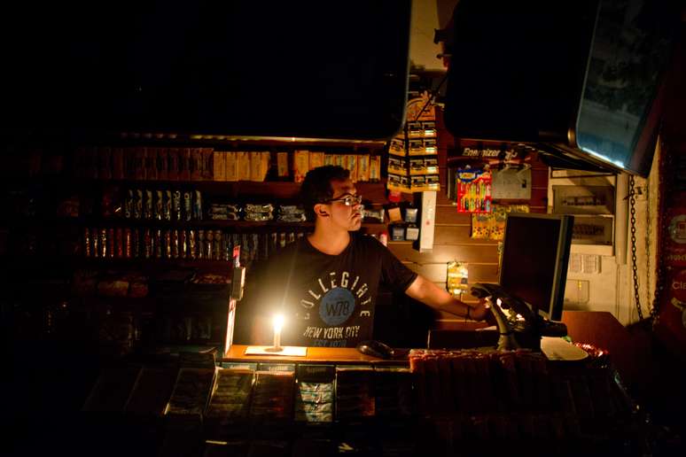 Comerciante trabalha à luz de velas durante blecaute em Buenos Aires