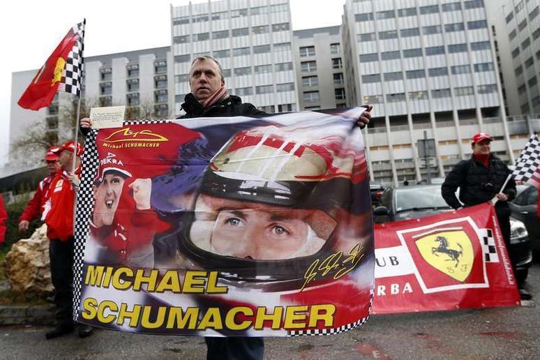 <p>F&atilde; franc&ecirc;s da Ferrari segura bandeira com a imagem de Schumacher em frente ao hospital</p>