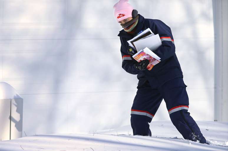 Funcion&aacute;ria do correio americano enfrenta grande volume de neve acumulado no ch&atilde;o de Springfield, no Estado de Illinois