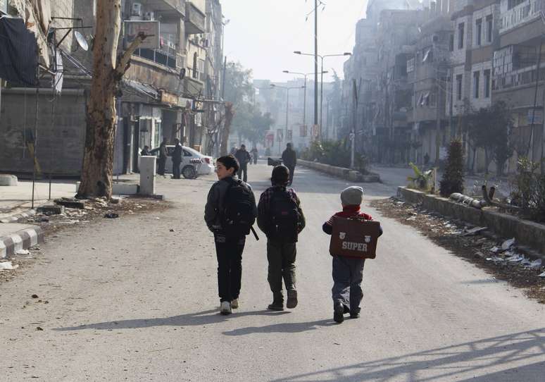 Meninos sírios se dirigem para escola em Arbeen, subúrbio de Damasco, em 1º de janeiro