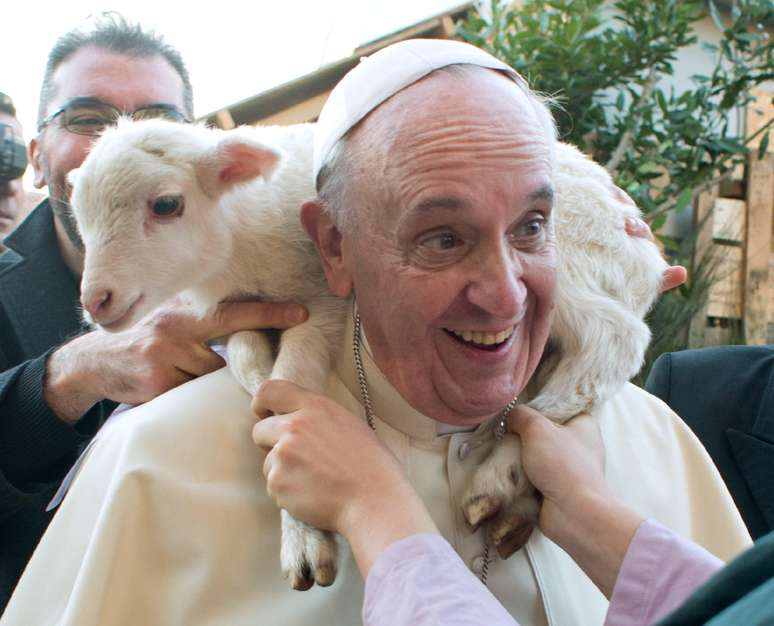 <p>Cordeiro &eacute; colocado ao redor do pesco&ccedil;o do papa Francisco durante visita do pont&iacute;fice a par&oacute;quia de St. Alfonso Maria de Liguori, nos arredores de Roma. O papa visitou uma encena&ccedil;&atilde;o viva do pres&eacute;pio em raz&atilde;o do Dia da Epifania do Senhor (6 de janeiro), quando os cat&oacute;licos relembram a jornados dos tr&ecirc;s reis magos para prestar homenagem a Jesus</p>