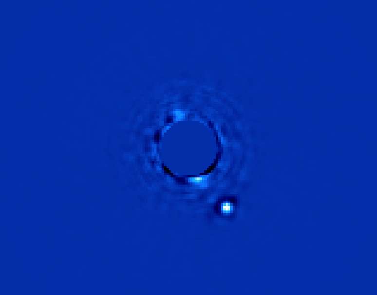 Beta Pictoris b, um planeta muito maior que Júpiter, é registrado pelo instrumento GPI ao lado de sua estrela, que tem o brilho escondido e aparece no centro da imagem. O GPI foi criado para registrar exoplanetas