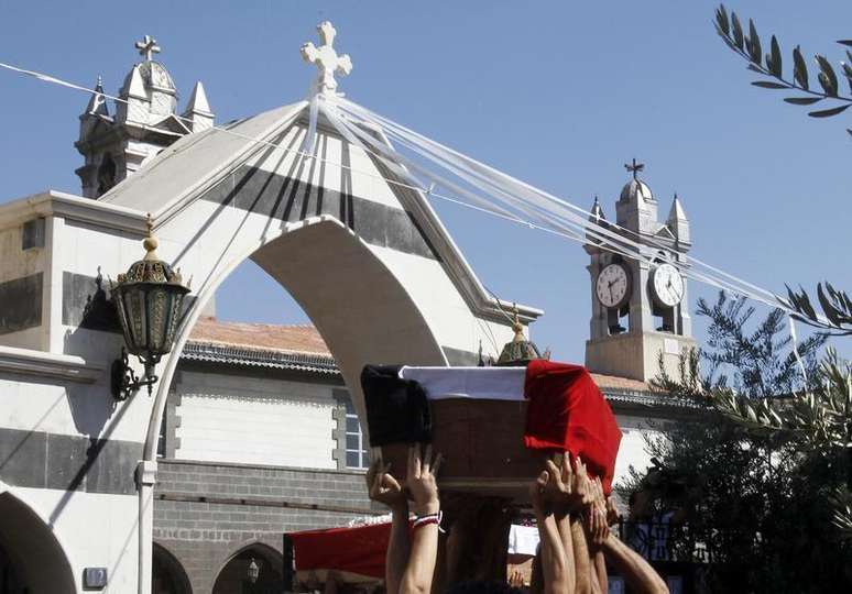 <p>Homens carregam caix&otilde;es de tr&ecirc;s crist&atilde;os, mortos enquanto iam para uma igreja para um funeral, em Damasco, em 10 de setembro</p>