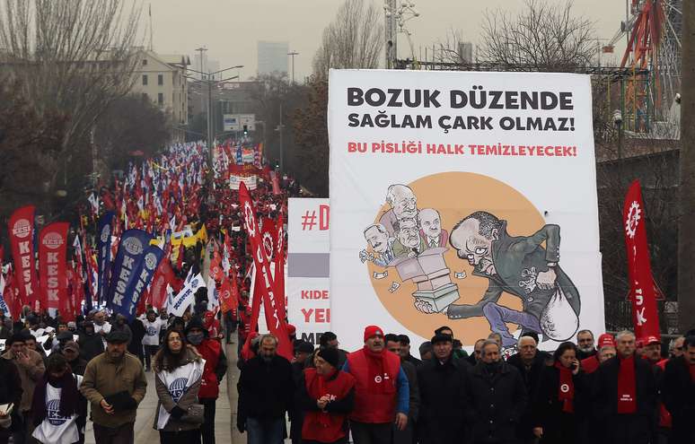 Manifestantes marcham com cartaz crítico ao governo do premiê Recep Tayyip Erdogan em Ancara, capital da Turquia