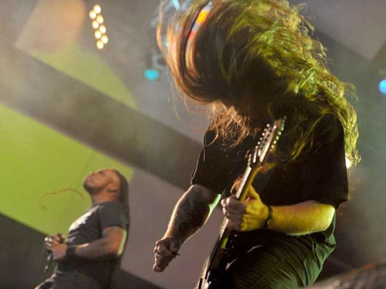 <p>Kisser agita com Derrick Green, do Sepultura, ao fundo</p>