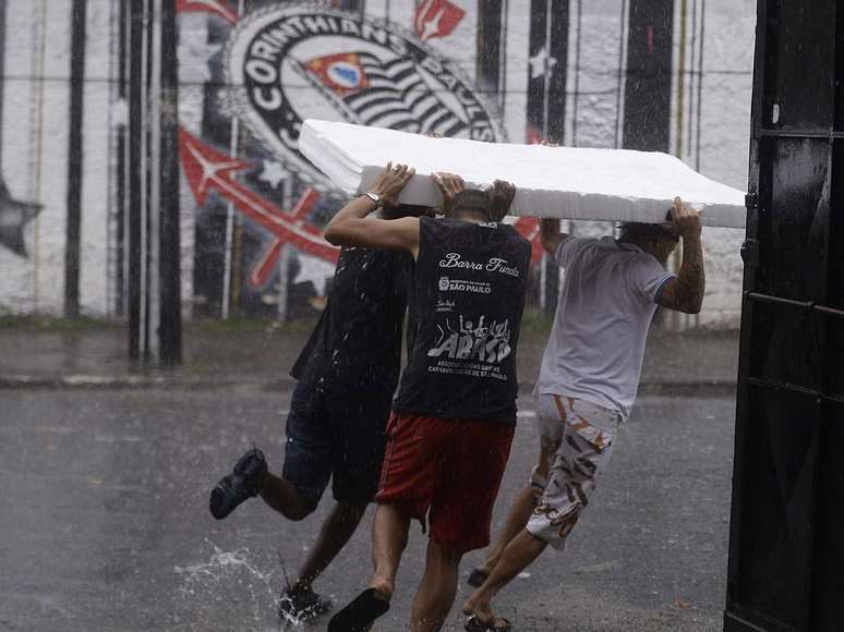 Grupo tenta se proteger da chuva no bairro de Bom Retiro, na região central de São Paulo