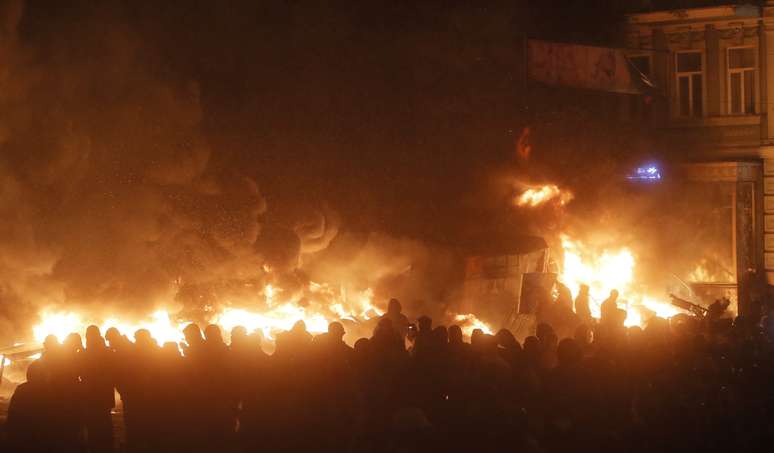 Manifestantes incendeiam barricada ao cair da noite após violentos protestos em Kiev