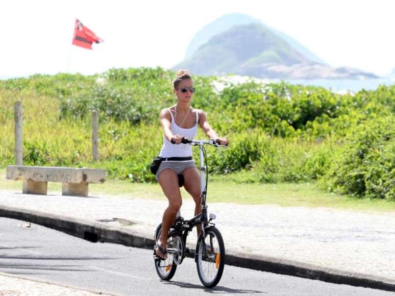 <p>Fernanda Freitas anda de bicileta na orla da praia</p>