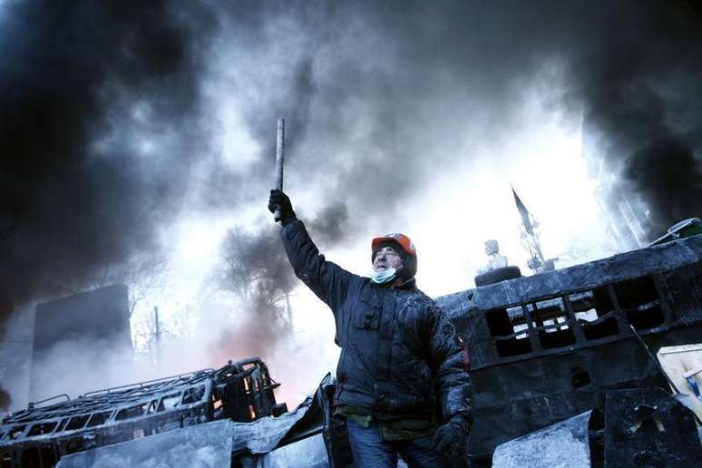 <p>Homem em barricada perto do local de conflitos entre manifestantes contra o governo e tropas de choque em Kiev, no dia 25 de janeiro de 2014</p>