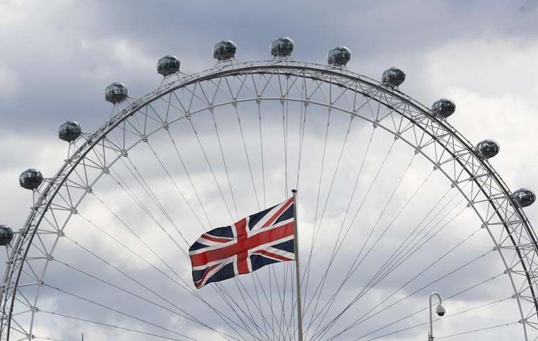 Uma bandeira do Reino Unido na frente do London Eye, em Londres; economia britânica desacelerou no 1º trimestre