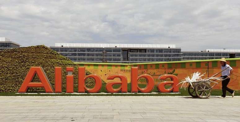 Funcionário passa pelo logotipo do Alibaba em sua sede em Hangzhou. O impressionante crescimento do Alibaba pode estar arrefecendo, mas só levemente. 24/08/2013