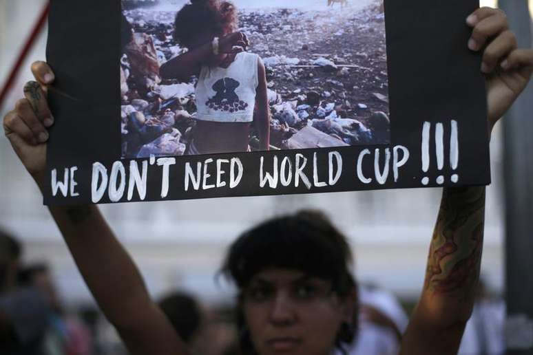 Manifestante ergue cartaz durante um protesto contra a Copa do Mundo de 2014, em Copacabana, no Rio de Janeiro. Preocupado com o movimento "não vai ter Copa" e com as críticas sobre a organização e os gastos para realização da Copa do Mundo, o governo prepara uma ofensiva com foco publicitário para reagir e transformar o evento em dividendo político para a presidente Dilma Rousseff, disse uma fonte do Executivo nesta sexta-feira. 25/01/2014.