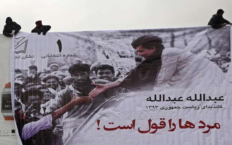 Homens instalam banner de campanha presidencial do candidato afeg&atilde;o Abdullah Abdullah, no primeiro dia de camapnha das elei&ccedil;&otilde;es presidenciais do Afeganist&atilde;o, em Cabul. 02/02/2014