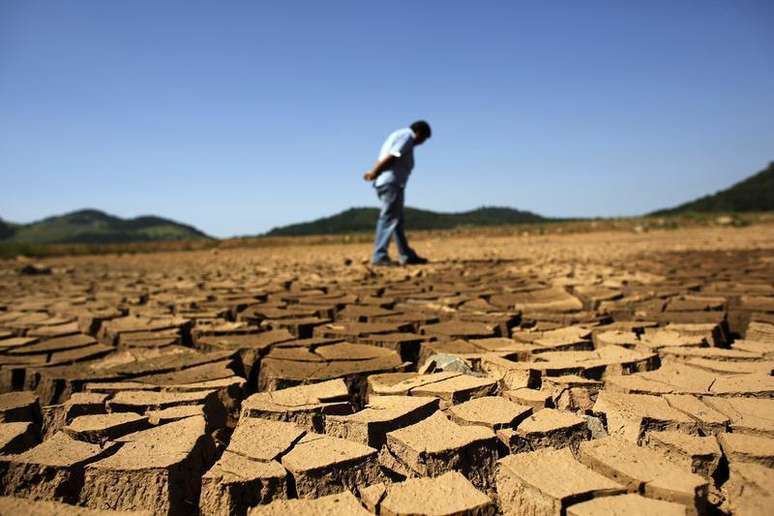 <p>Funcion&aacute;rio da Sabesp olha para o ch&atilde;o rachado na represa de Jaguary em Bragan&ccedil;a Paulista</p>