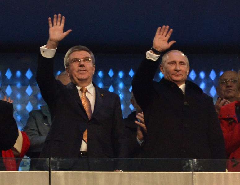 Thomaz Bach, do Comitê Olímpico Internacional, e o presidente russo Vladimir Putin acenam no Estádio Olímpico
