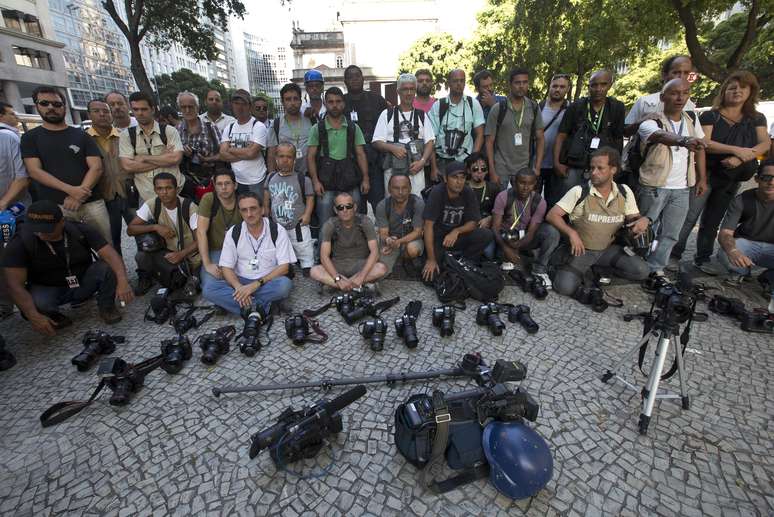 <p>Fotógrafos, jornalistas e cinegrafistas colocam as câmeras no chão em frente à igreja da Candelária e fazem um minuto de silêncio pela morte do cinegrafista Santiago Andrade, da Band, que morreu após ser atingido por um rojão na cobertura de um protesto no Rio, em 10 de fevereiro</p>