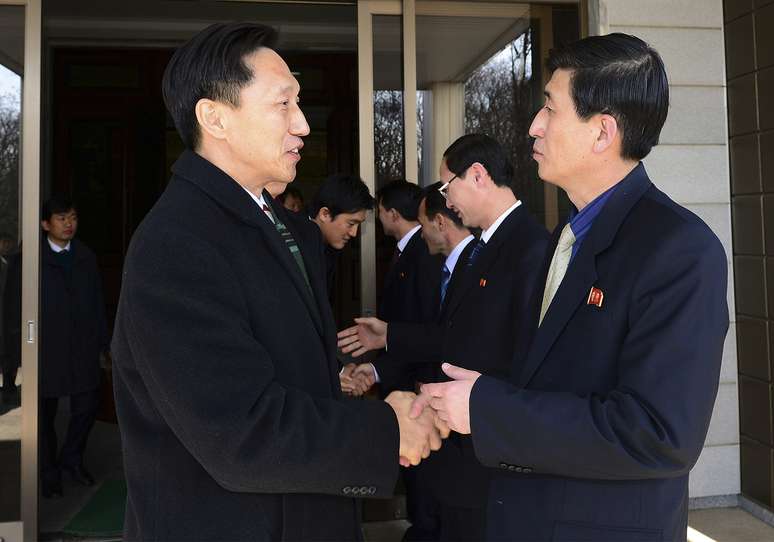 <p>Na foto divulgada pelo Ministério de unificação da Coreia do Sul, o líder da delegação da Coreia do Sul Lee Duk-haeng cumprimenta o líder da Coreia do Norte Park Yong II</p>